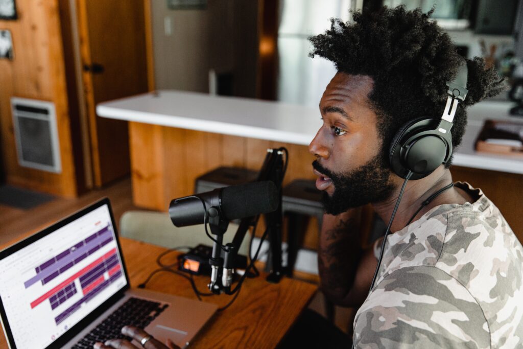 How Do I Start A Successful Podcast And Monetize It? 1 podcast man in camouflage shirt sitting in front of laptop computer